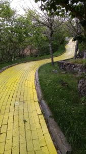 yellow brick road with grass and trees to each side