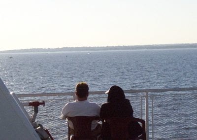 Two people viewing the Long Island Sound from the upper deck of the PT Barnum.