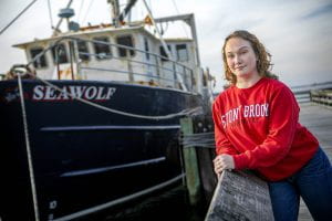 Amanda Thomas standing in front of the R/V Seawolf