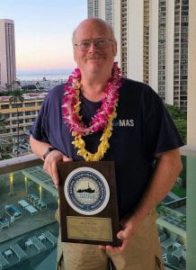 Tom Wilson stands with his plaque commemorating his service to RVTEC and UNOLS at the annual meeting of RVTEC at the University of Hawaii in Honolulu.